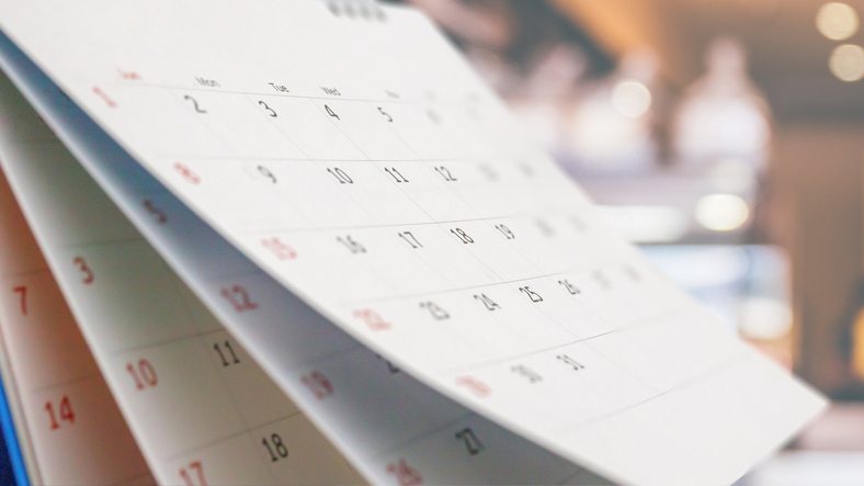Close up white paper desk calendar with blurred bokeh background